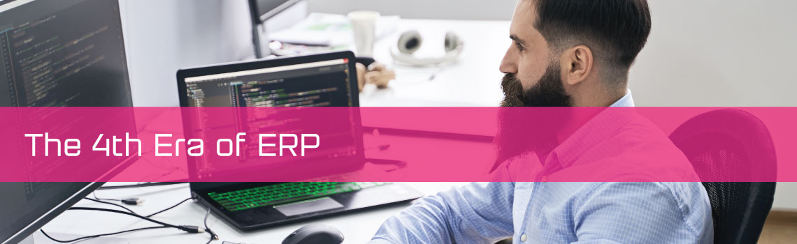 A man working on a laptop and desktop with a copy strap that reads The 4th era of ERP