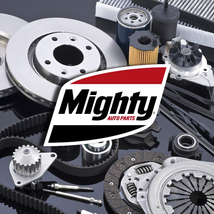 Autoparts on a table with the Mighty Distributing System logo 