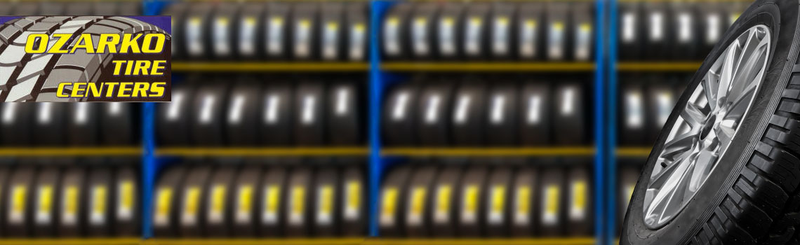 Shelves of tires with the Ozarko Tire Centers logo on.
