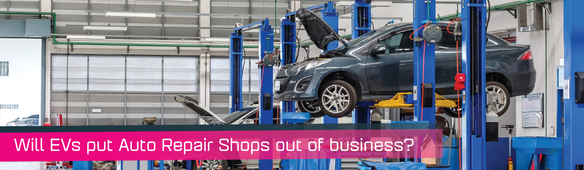 A car on a lift in an auto repair shop.